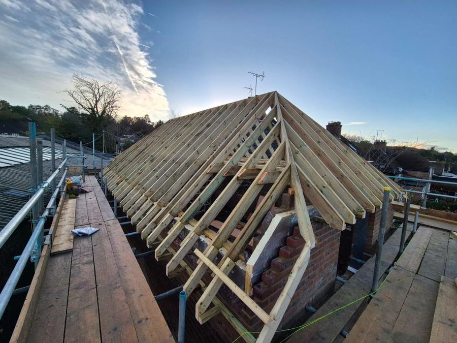 A new roof — A freshly cut timber roof structure going up over an existing property.