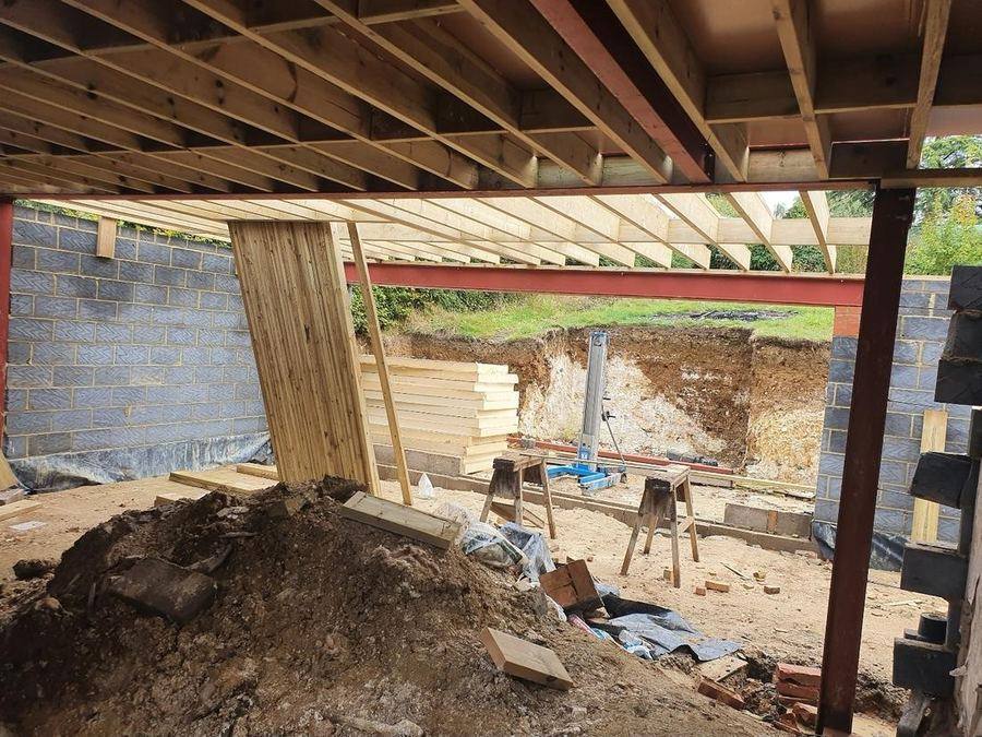 Steel & timber — Steel beams and timber joists forming the structure over a lower-ground level.